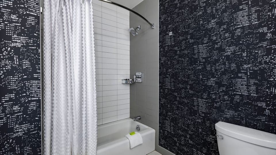 Rinse off in a clean tub-shower with modern tilework