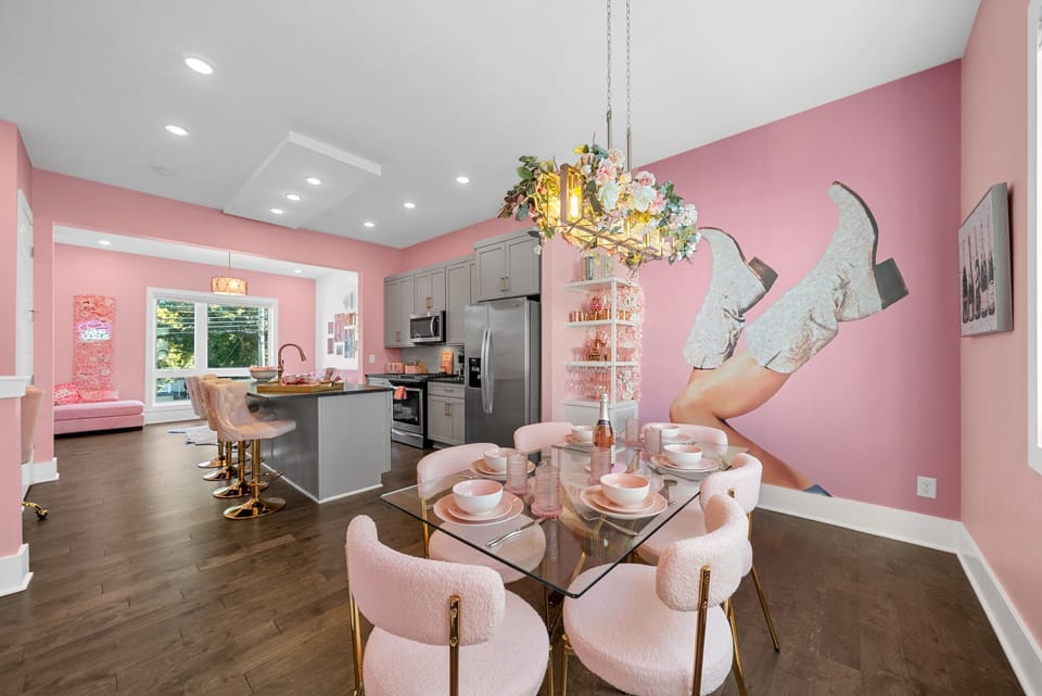 Pink dining room with a striking mural and table for six.