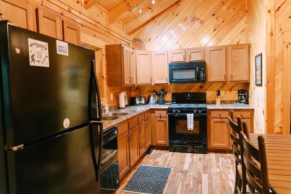 Well equipped kitchen with refrigerator, dishwasher, double sink, oven, stovetop and microwave.