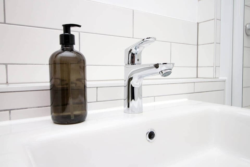Modern, hotel-style bathroom with full bath and overhead rainfall shower. Finished with sleek fittin