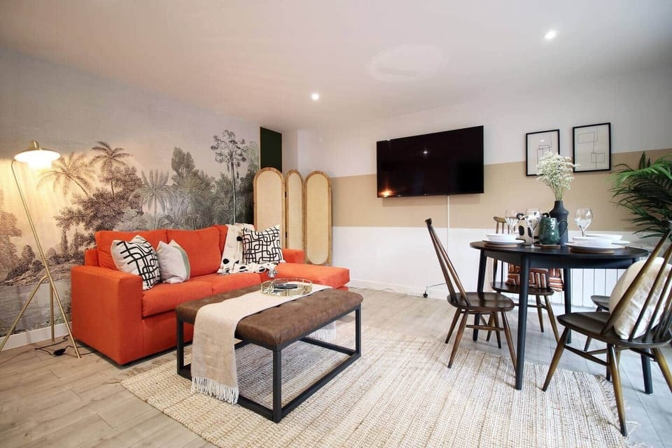 “Bright, stylish open-plan living area with a comfortable sofa bed, large Smart TV, and dining space