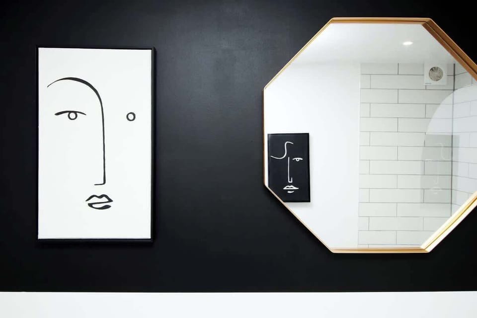Modern, hotel-style bathroom with full bath and overhead rainfall shower. Finished with sleek fittings, fresh white tiling, and plush towels, creating a clean, relaxing space perfect for unwinding after a day out.