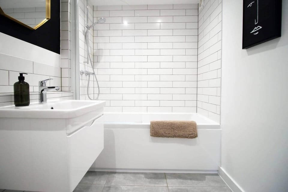 Modern, hotel-style bathroom with full bath and overhead rainfall shower. Finished with sleek fittin