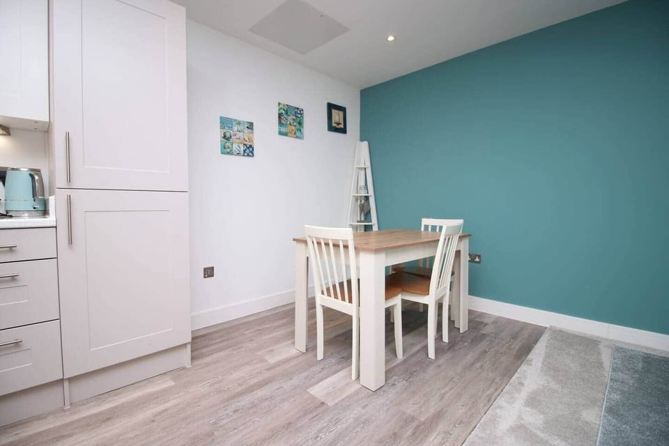 A bright, contemporary dining space featuring a stylish wooden table and seating for four,