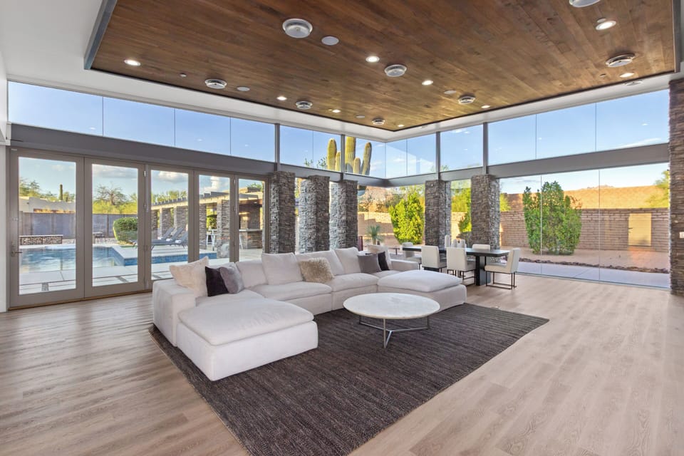 Enjoy ample seating on the sectional, a stylish white coffee table, and elegant wood-paneled ceilings.