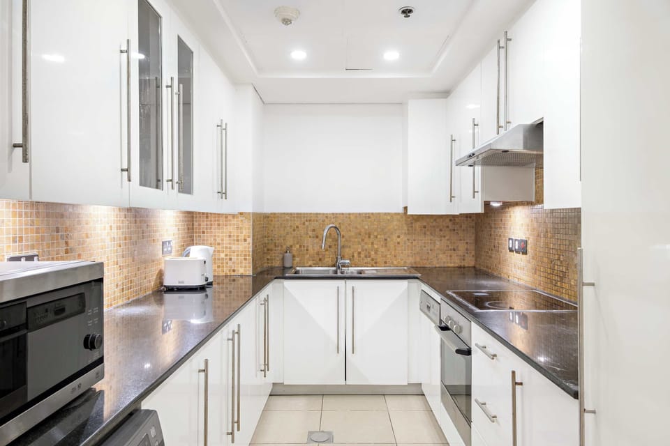 Sleek kitchen w/ smooth cabinets & warm lighting