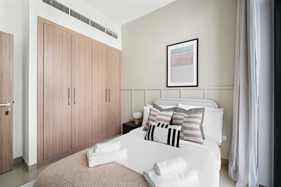 Master bedroom featuring tall curtains & serene colors