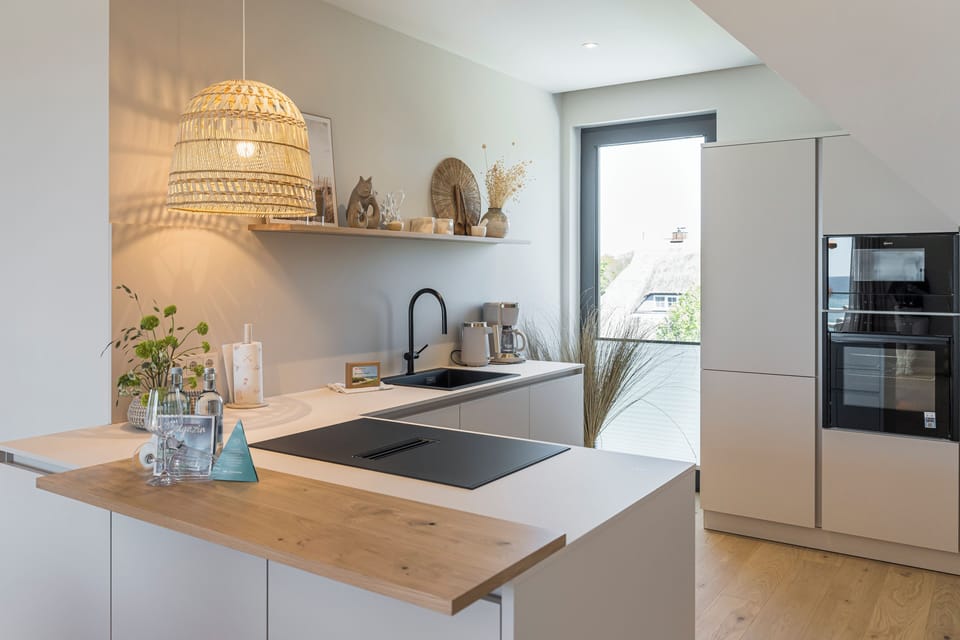 Modern kitchen with wooden countertop and window.