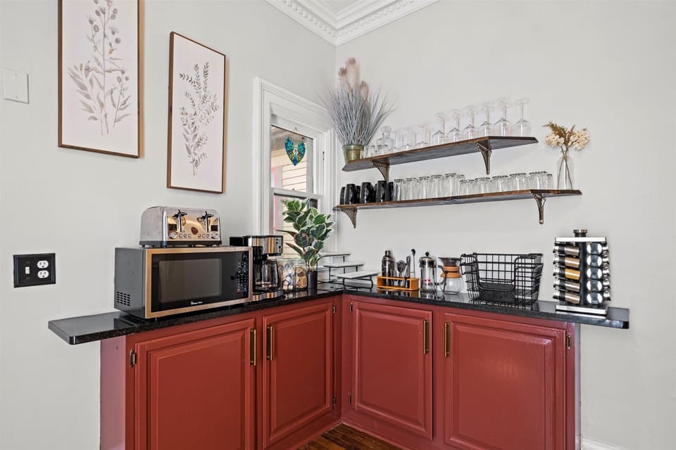Fully equipped kitchen with dedicated coffee station, microwave, and small appliances, thoughtfully set up for longer stays in this historic Victorian home.