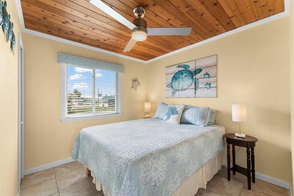 Peaceful bedroom with soft seafoam tones and wood ceiling - ideal for a restful night’s sleep