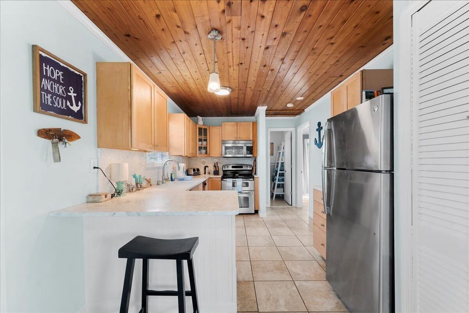 Open kitchen with modern appliances and a breakfast bar for casual meals or morning coffee.