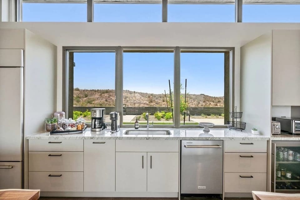 The fully equipped luxury kitchen is stocked with all culinary essentials and features high-end stainless-steel appliances, 2 kitchen islands, 2 breakfast tables, 6 person dining tables, and a wet bar/coffee station.