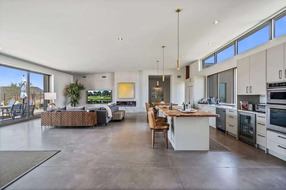 Spacious, light, and bright living room featuring an electric fireplace, wet bar, Smart TV, and designer furnishings.
