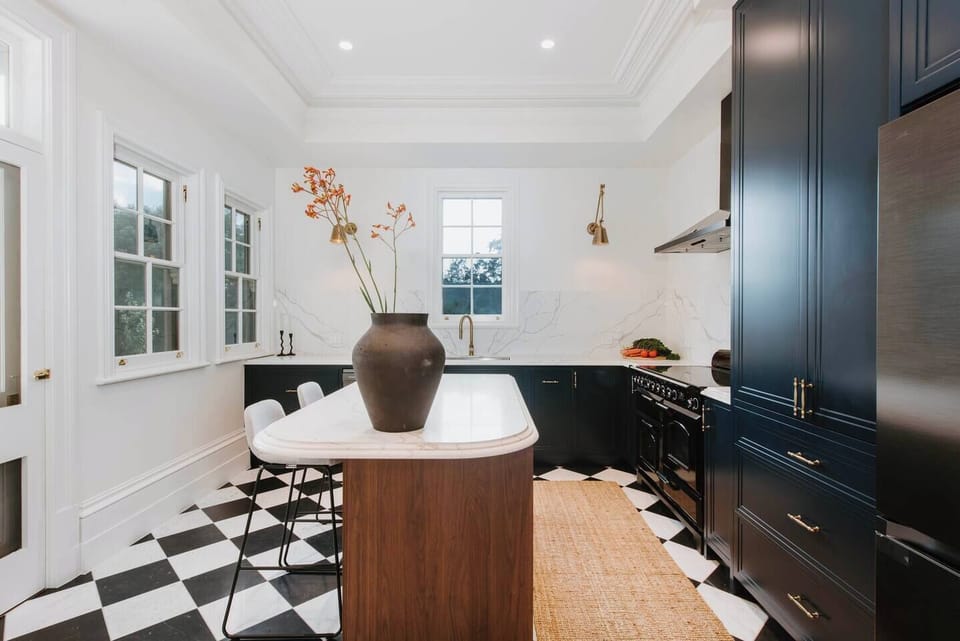 Whip up something special in the chef’s kitchen, where modern appliances, a central island, and striking checkerboard floors set the scene for effortless cooking in style.