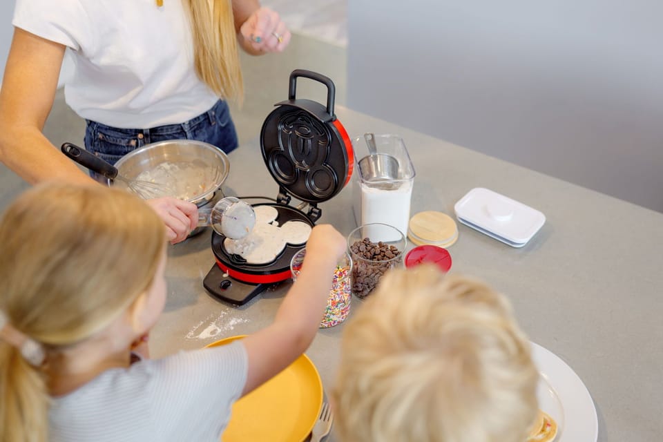 Mickey Mouse waffle bar with mix, toppings, and recipe card—fun for kids!