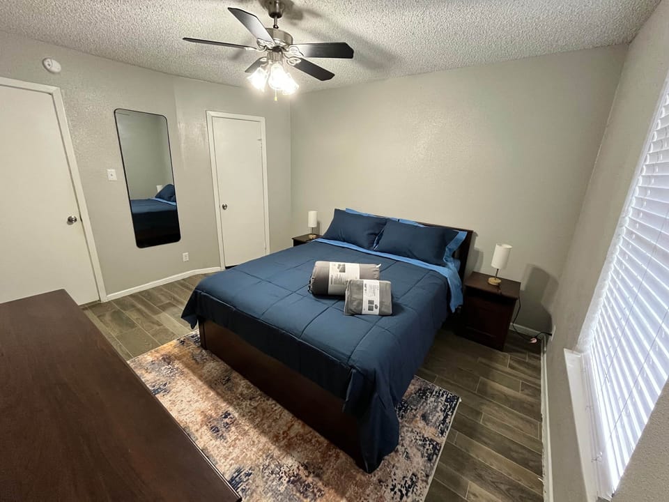 Cozy bedroom with a comfortable queen bed, dresser, and closet space. Includes ceiling fan, soft lighting, and modern décor. Perfect for a restful night’s sleep after exploring Houston.