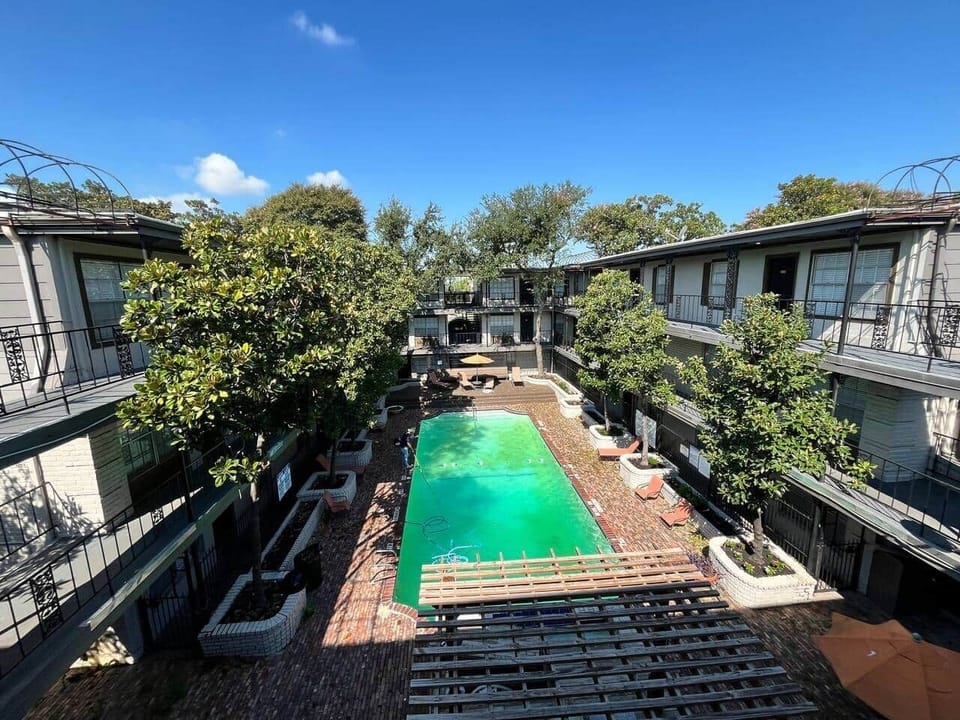 Community outdoor lounge with shaded seating, BBQ grill, and poolside relaxation area. A perfect spot to gather, cook out, or unwind under the pergola.
