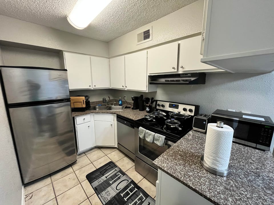 Fully equipped kitchen with stainless steel fridge, stove, oven, microwave, and dishwasher. Stocked with cookware, dishes, and essentials for cooking or dining in. Perfect for preparing meals during your stay.