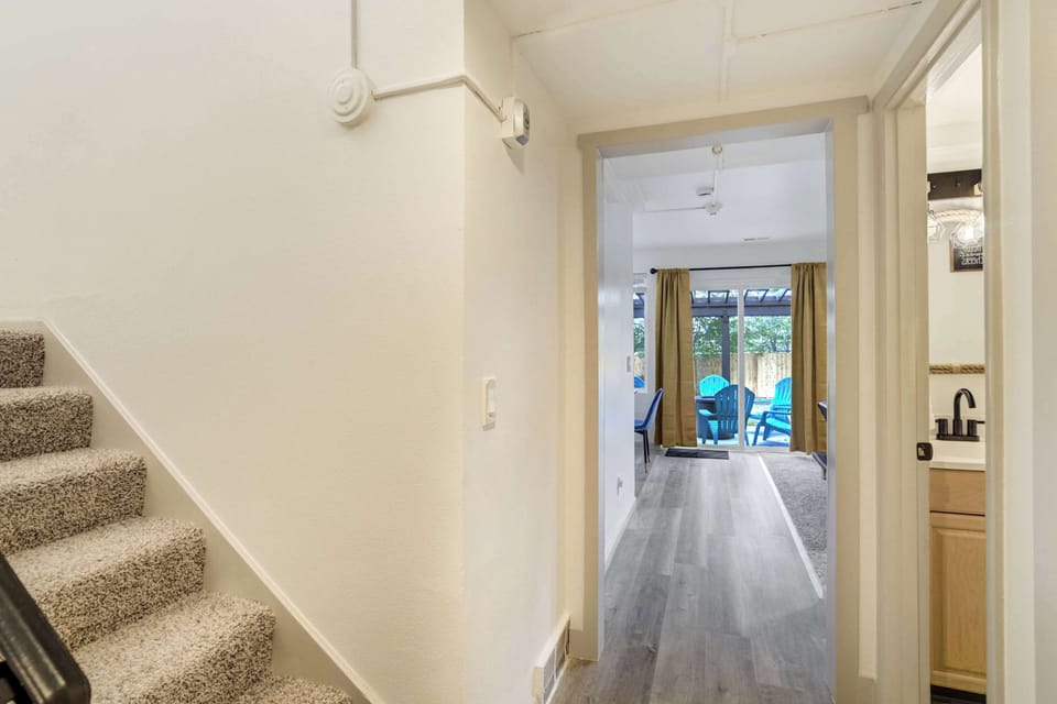 Welcoming entryway leading from the stairs to the main living areas with a direct line of sight to the backyard patio.