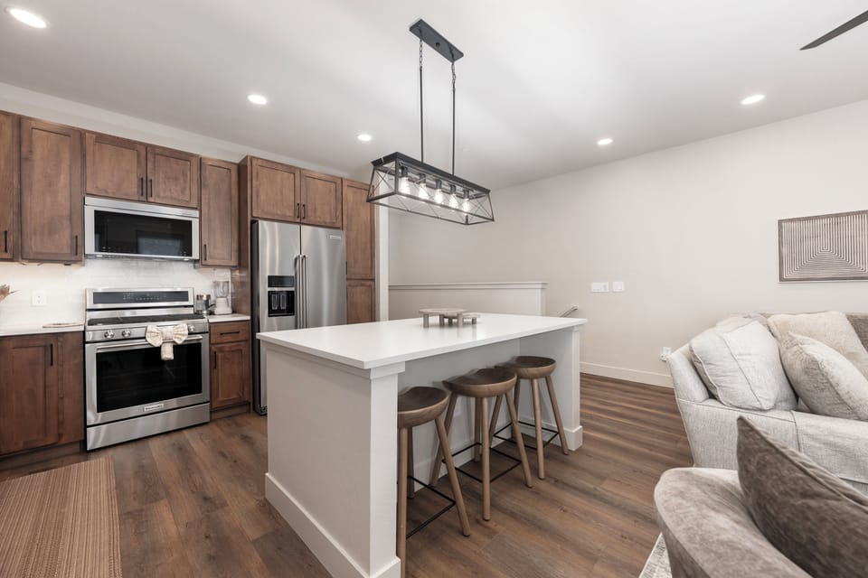Your open-concept kitchen flows seamlessly into the living space, featuring warm wood cabinets, modern appliances, and a stunning island perfect for morning coffee.