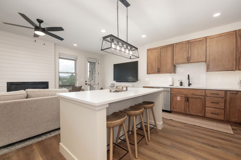 Your open-concept kitchen and living space combines modern elegance with warm wood accents, featuring a stunning island for cooking and casual dining.