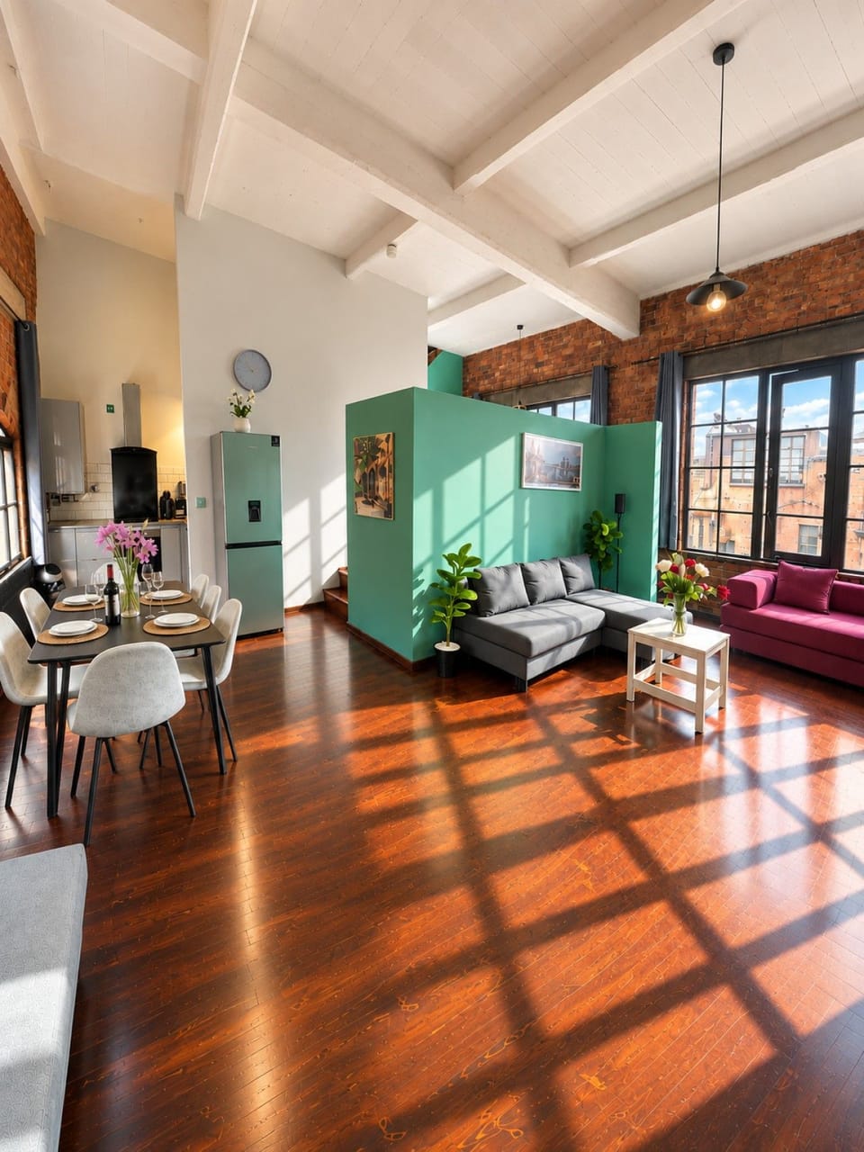Spacious loft-style interior featuring exposed brickwork, comfortable seating and a fully equipped kitchen and dining area.