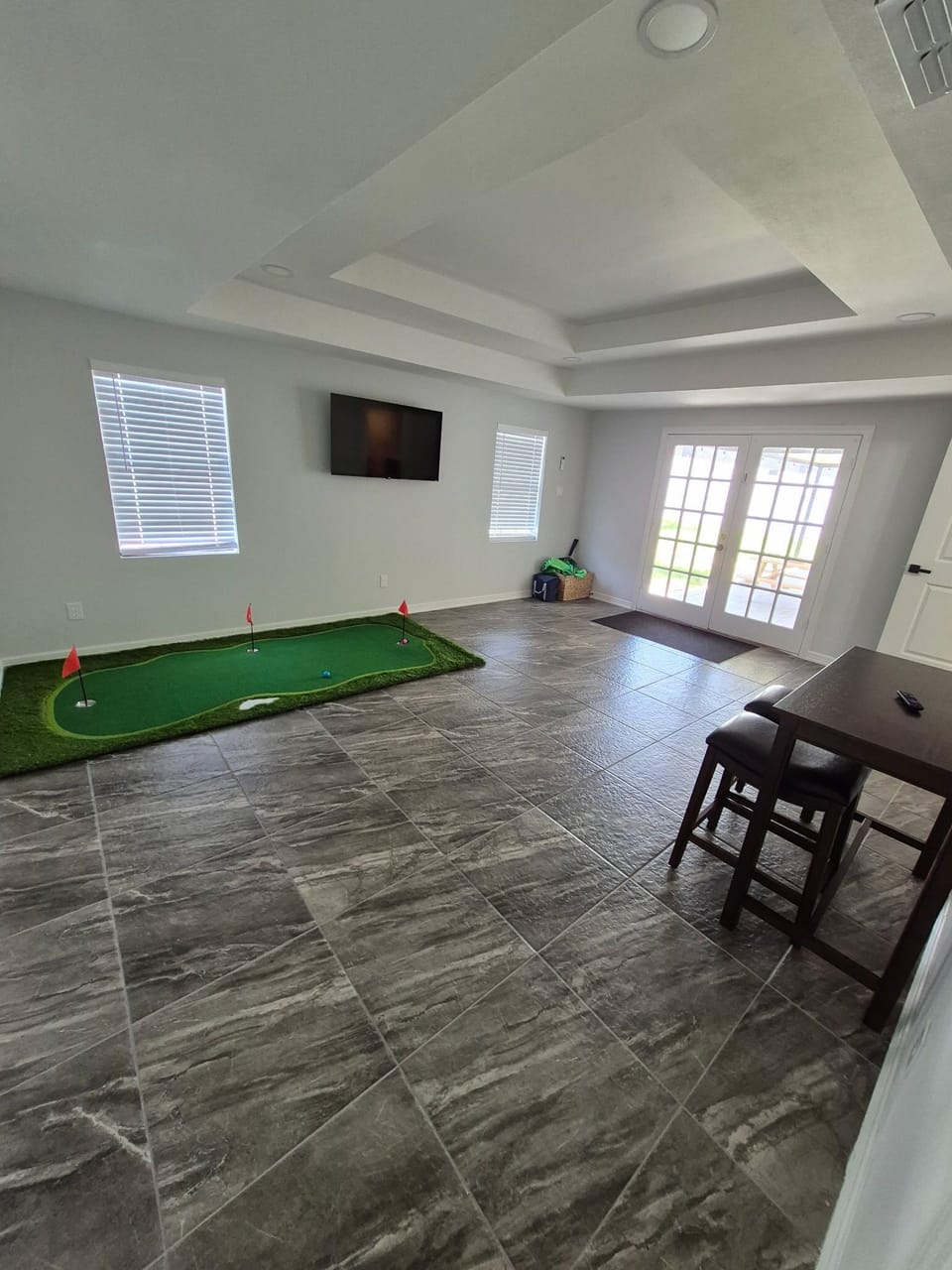 Game room has mini golf, TV, and sofa sleeper.