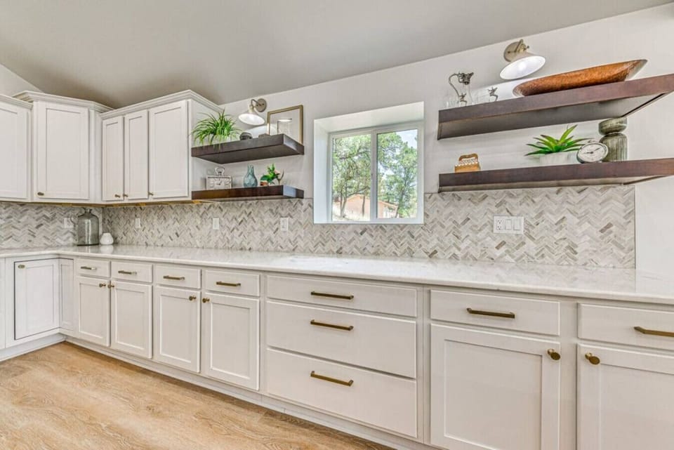 Kitchen | Spacious counter space with sleek white cabinetry and modern open shelving