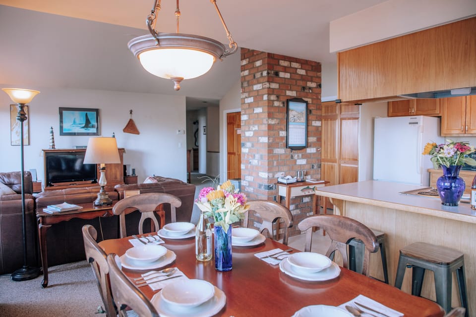 Open dining area with seating, full kitchen, and living room flow.