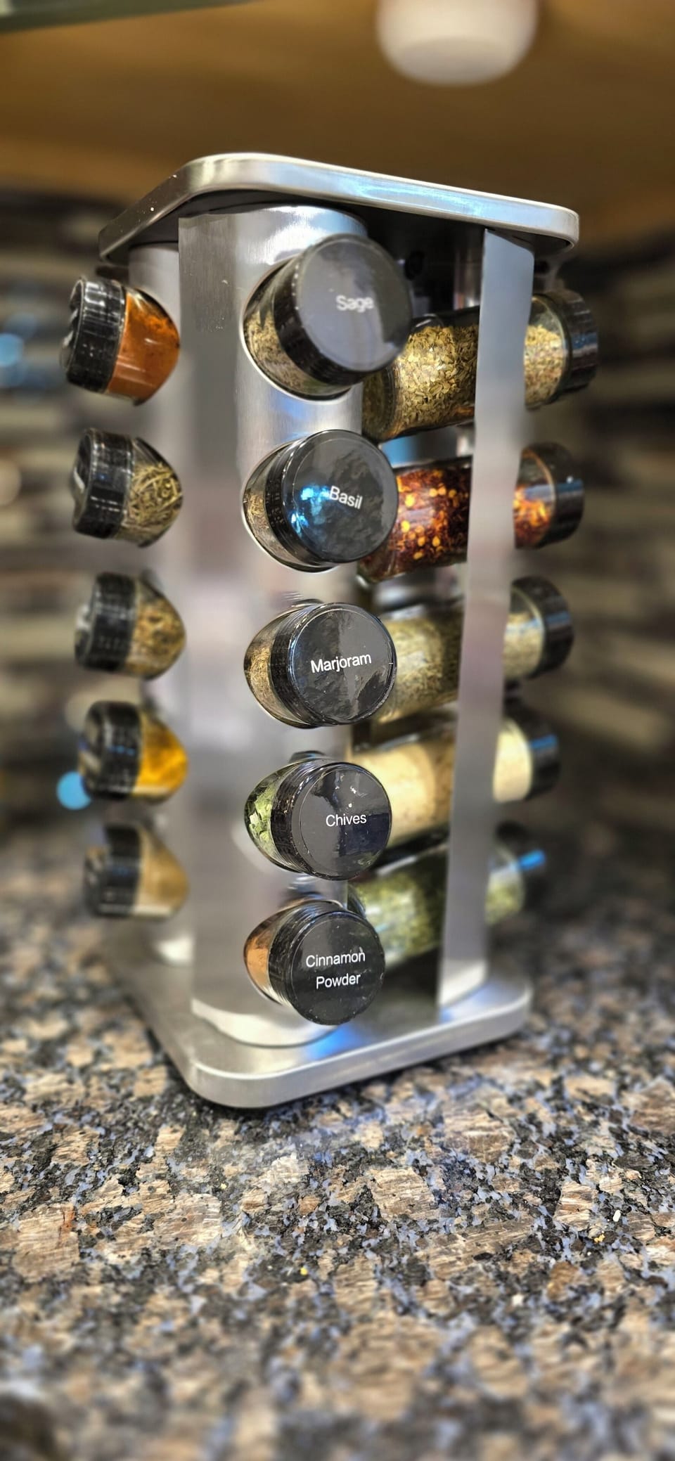 Well-stocked spice rack on granite countertop
