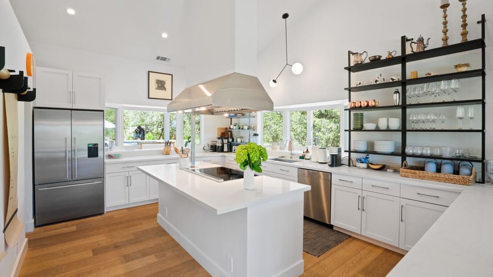 Kitchen equipped with electric stovetop, oven and small coffee bar.