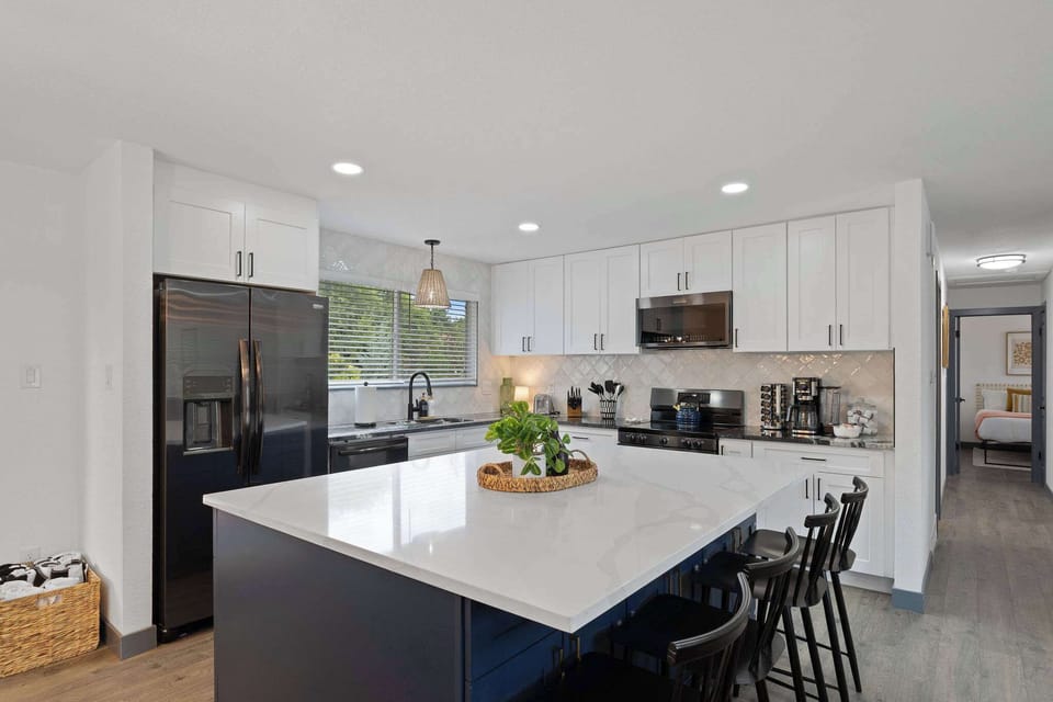 The remodeled kitchen has a large island with seating in the middle. 