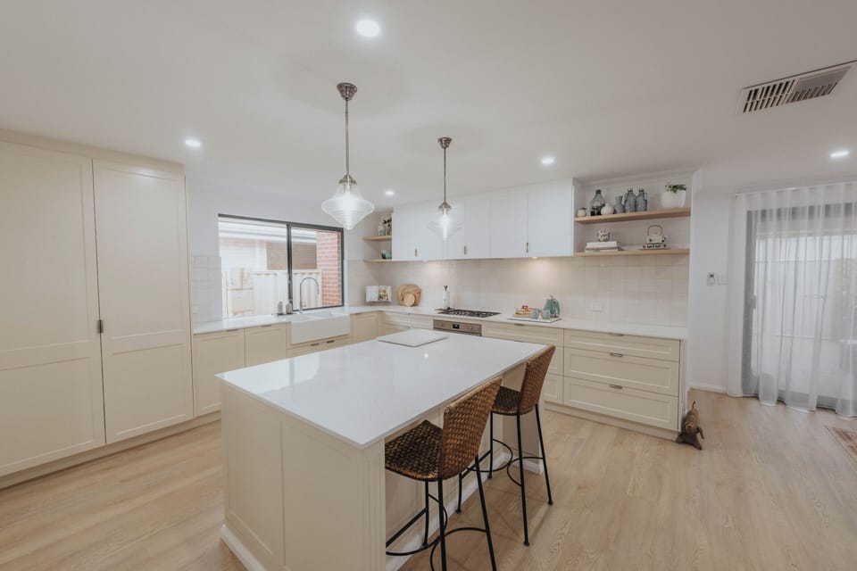 Island bench overlooks the butler sink. Extra appliances stored in the pantry.