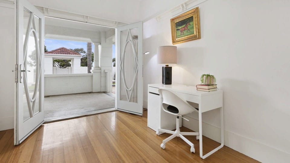 Study with doors opening to a covered patio, perfect for catching the coastal breeze. 