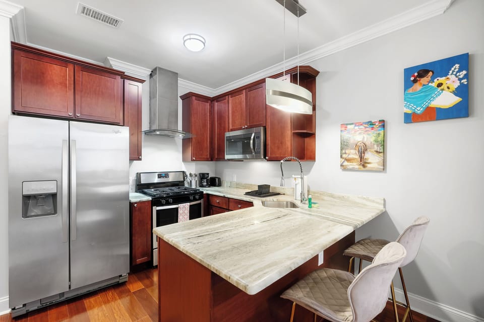 Fully equipped kitchen with modern appliances, granite countertops, and ample cabinet space.