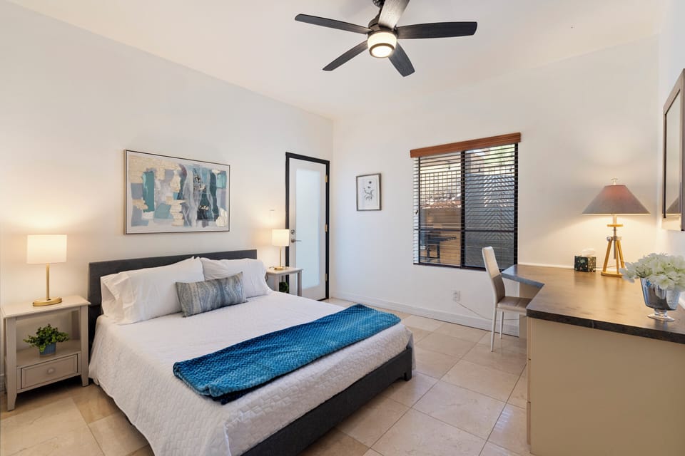 queen bedroom with built in desk and private entrance to courtyard