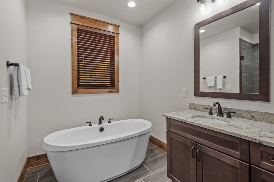 Soak your cares away in the freestanding tub, paired with warm wood trim and a granite vanity.