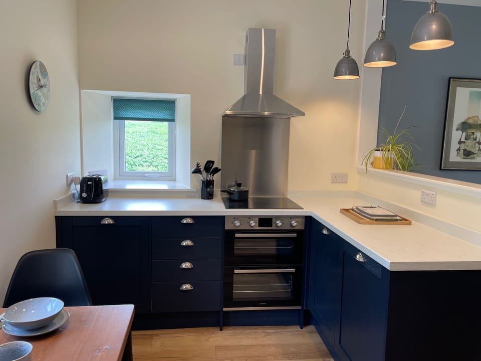 The kitchen area has a full cooker fridge and freezer