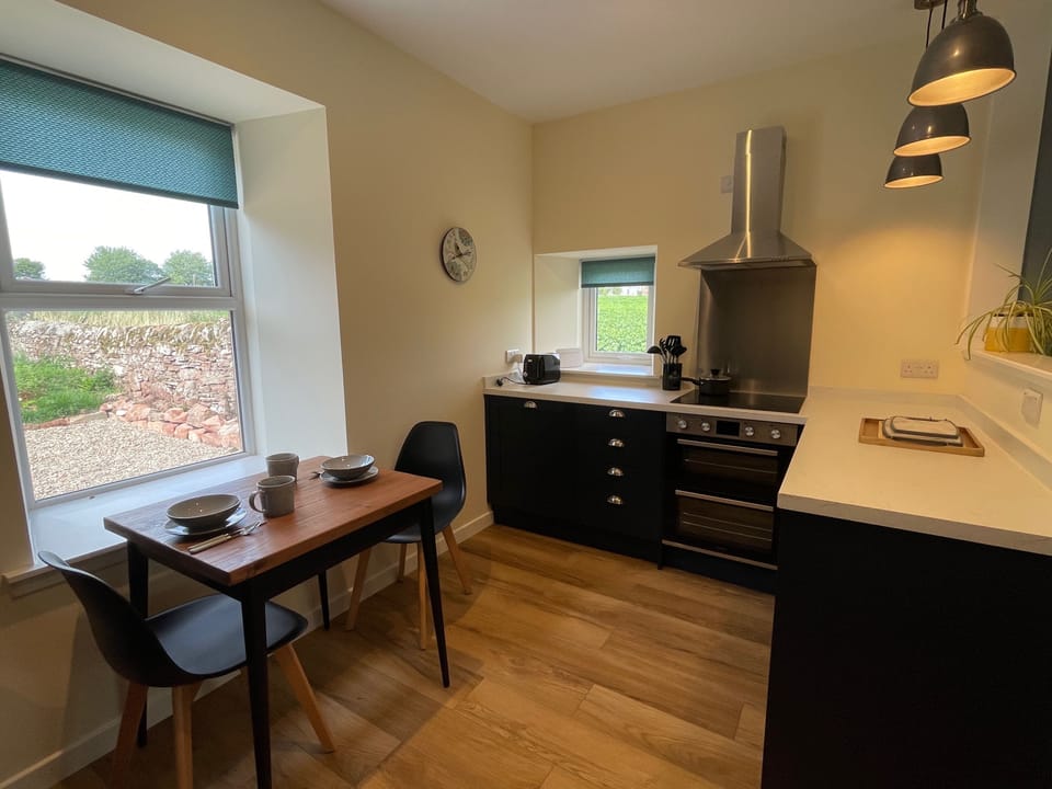 There is a  small dining table in the kitchen area