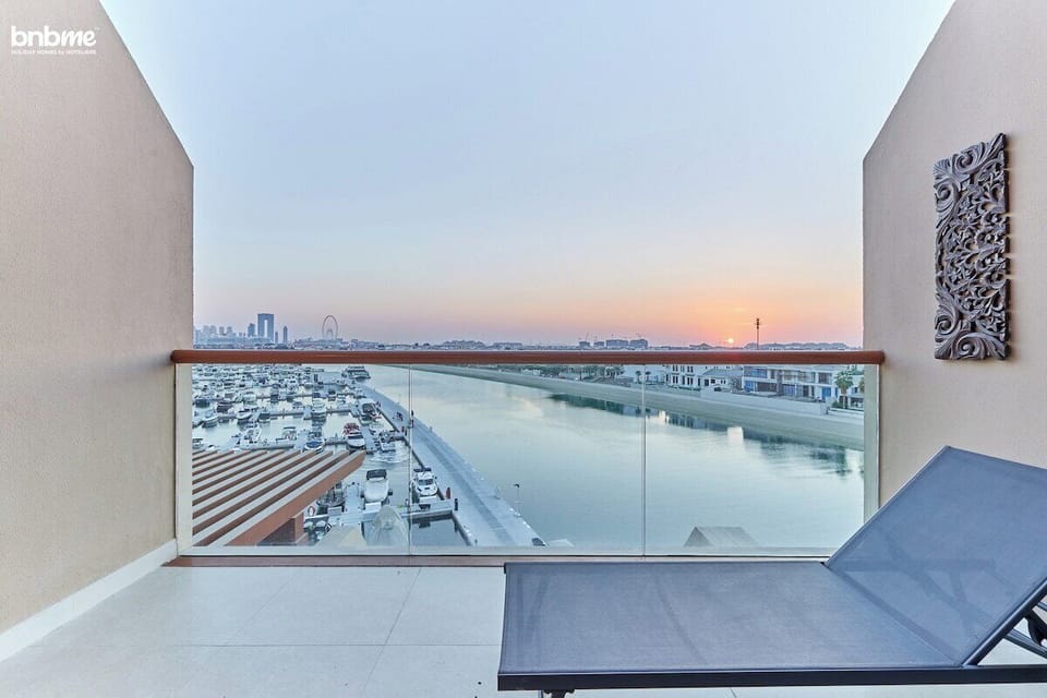 Unwind on the private balcony featuring a sun lounger, single-seater hammock, and breathtaking views of the sea and Ain Dubai.