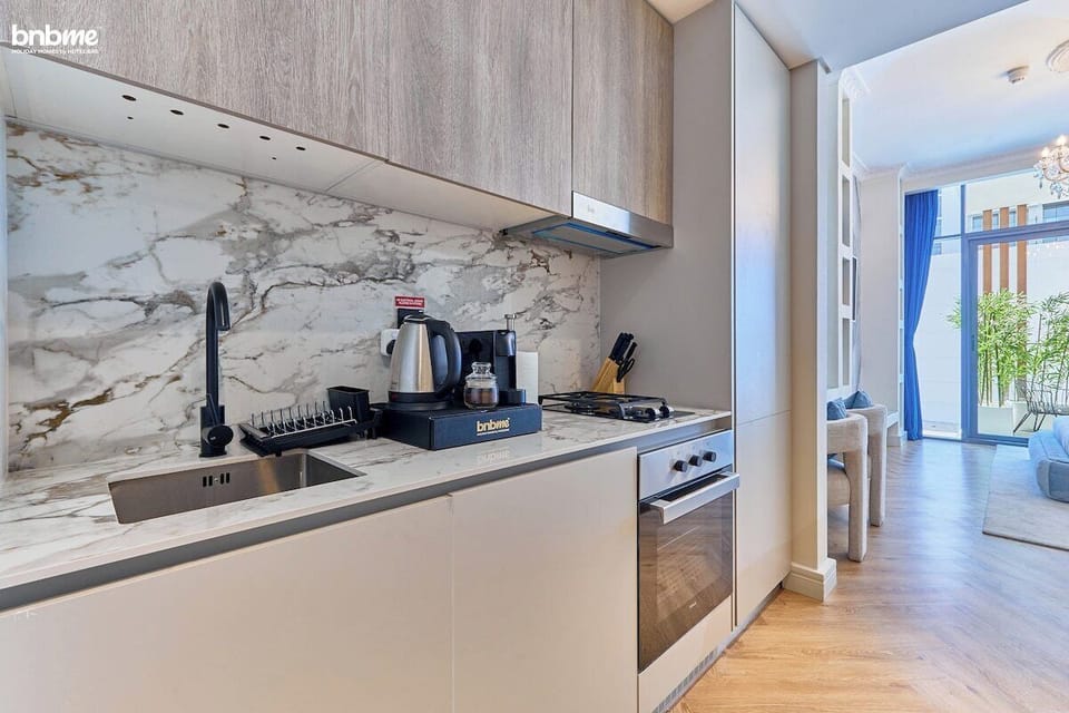 Sleek and fully equipped, this modern kitchen features high-end appliances, a stylish marble backsplash, and ample storage. Whether you're brewing your morning coffee or preparing a home-cooked meal, everything you need is right at your fingertips.