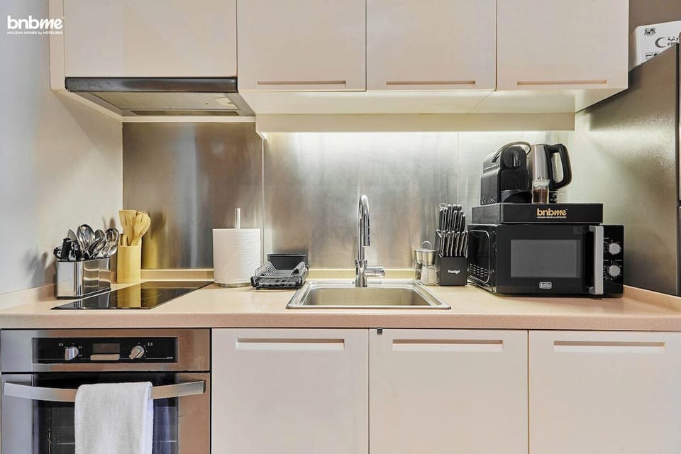 Whip up meals anytime in this sleek kitchen, complete with a stovetop, fridge, microwave, and all the utensils you need for a hassle-free cooking experience.