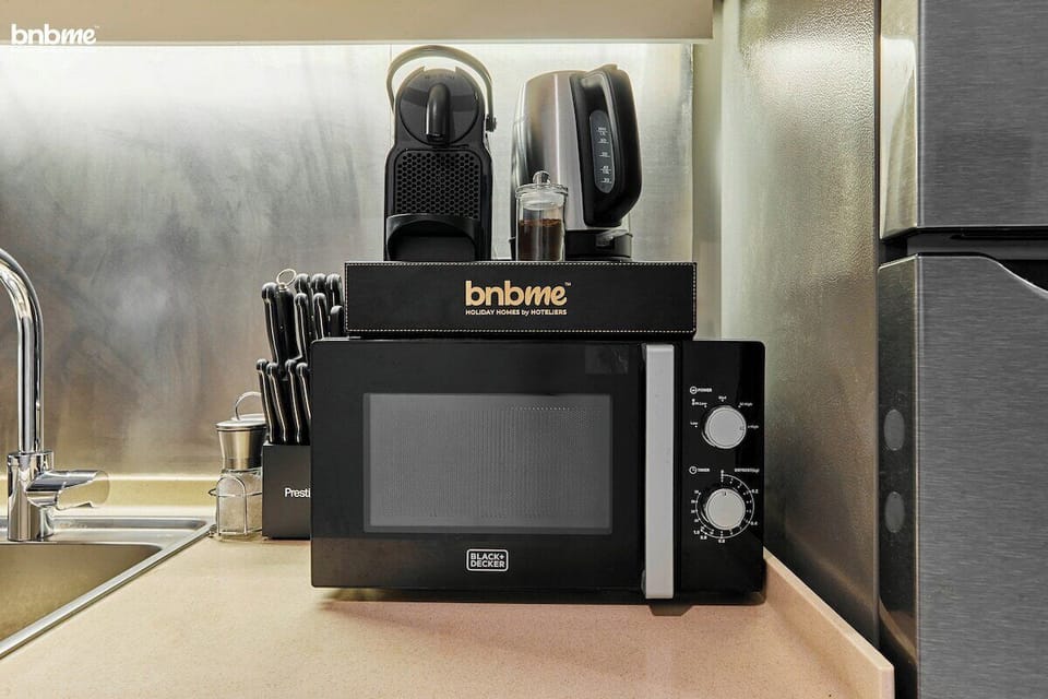 Whip up meals anytime in this sleek kitchen, complete with a stovetop, fridge, microwave, and all the utensils you need for a hassle-free cooking experience.