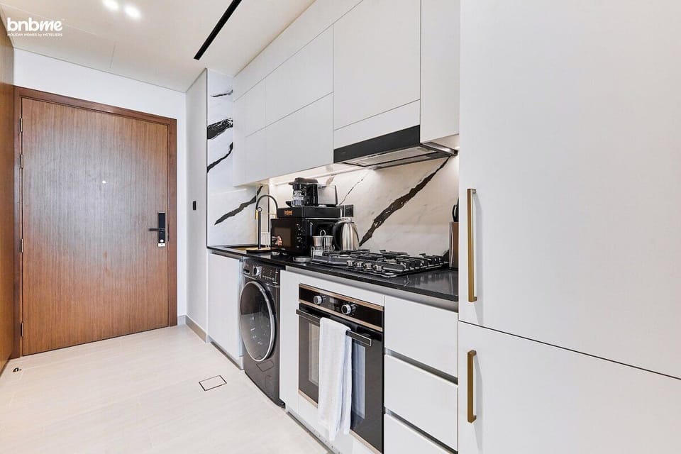 Cook up your favourites in a sleek, fully equipped kitchen featuring a gas stove, oven, microwave, coffee machine, kettle, washer/dryer combo, and ample cabinetry—perfect for extended stays or quick gourmet bites.