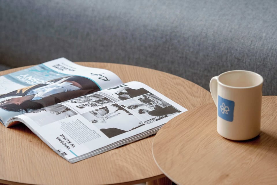 A small table with a mug of coffee and a newspaper creates a pleasant corner for a quiet morning or evening rest.