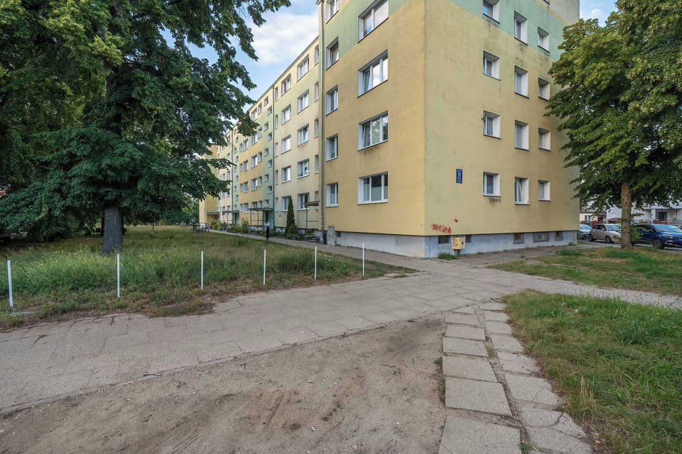 The view of the street with greenery in front of the building gives the area a calm and pleasant atmosphere.