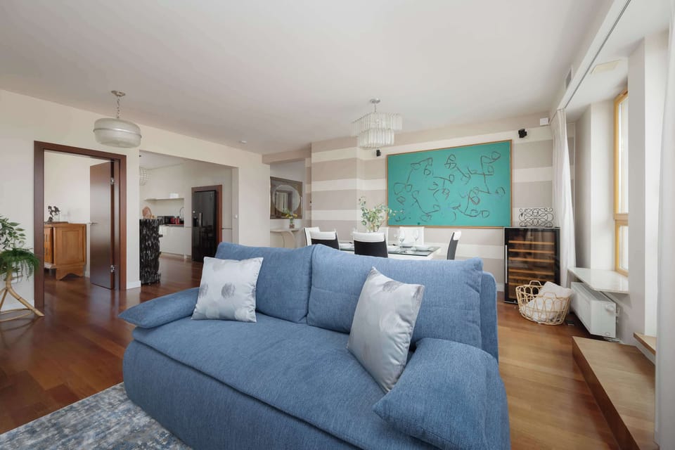 Bright living space with comfortable blue sofa and large windows.