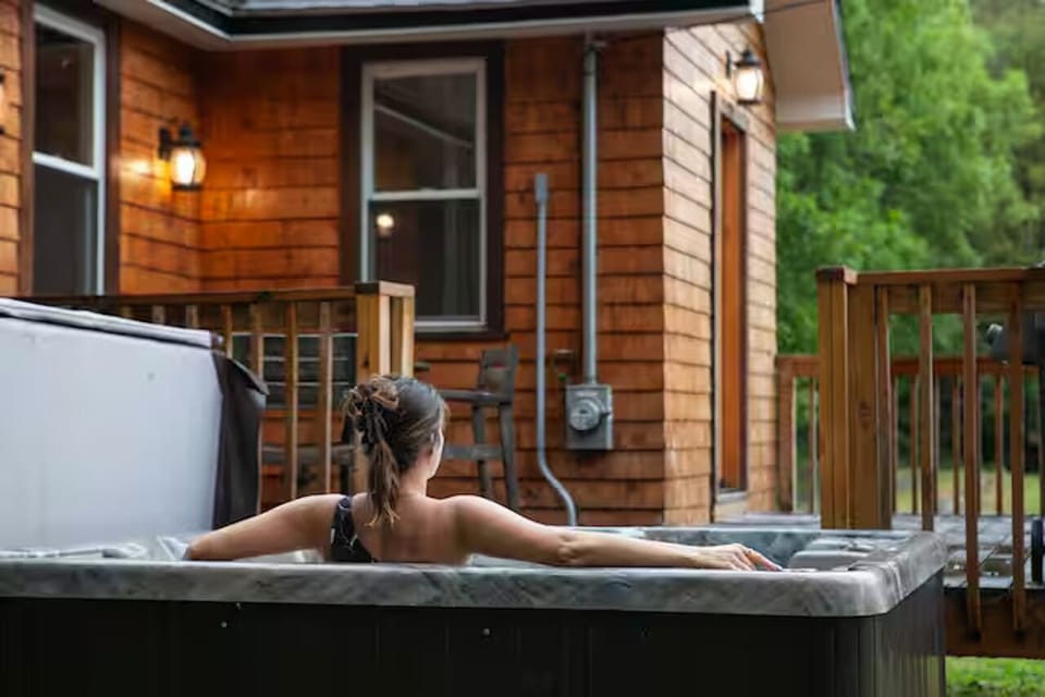Steam rises under cedar skies—your peaceful reset button beneath the stars.
