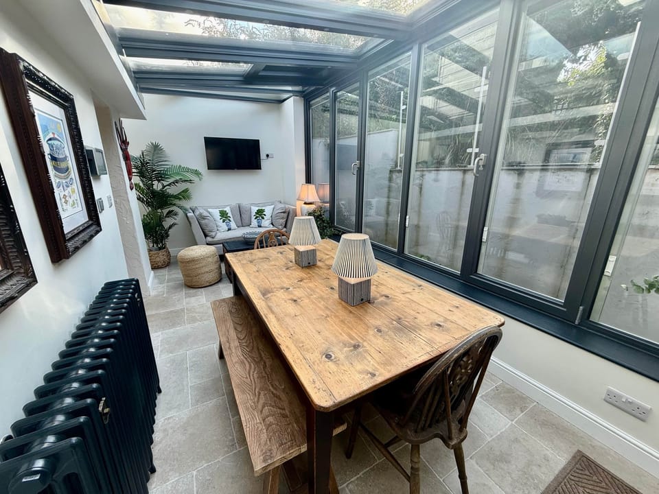 Spacious dining area with large rustic wooden table and vintage bifold doors