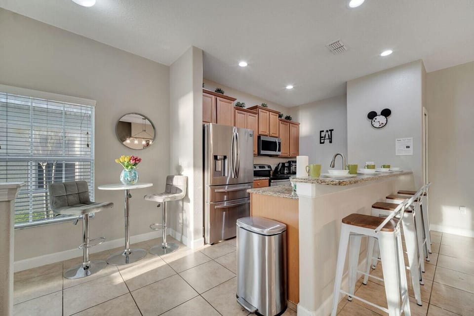 Fully equipped kitchen with stainless steel appliances, breakfast bar, and cozy dining nook.